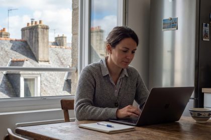 Femme en bureau à Quimper avec vue sur toits en ardoise