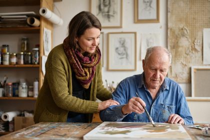 Femme guidant un homme âgé dans un atelier d'art